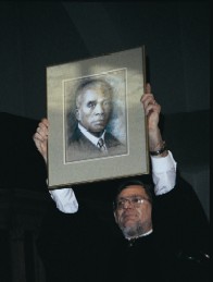 The Rev. Morris Hudgins shows a portrait of the Rev. W.H.G. Carter during the service of reconciliation at the First Unitarian Church of Cincinnati
