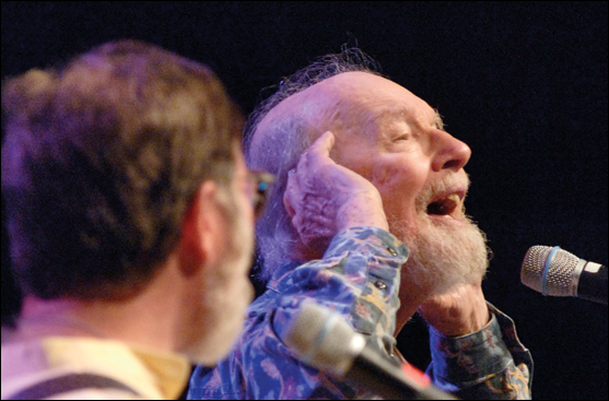 Pete Seeger singing at a microphone. © Nancy Pierce/UUA